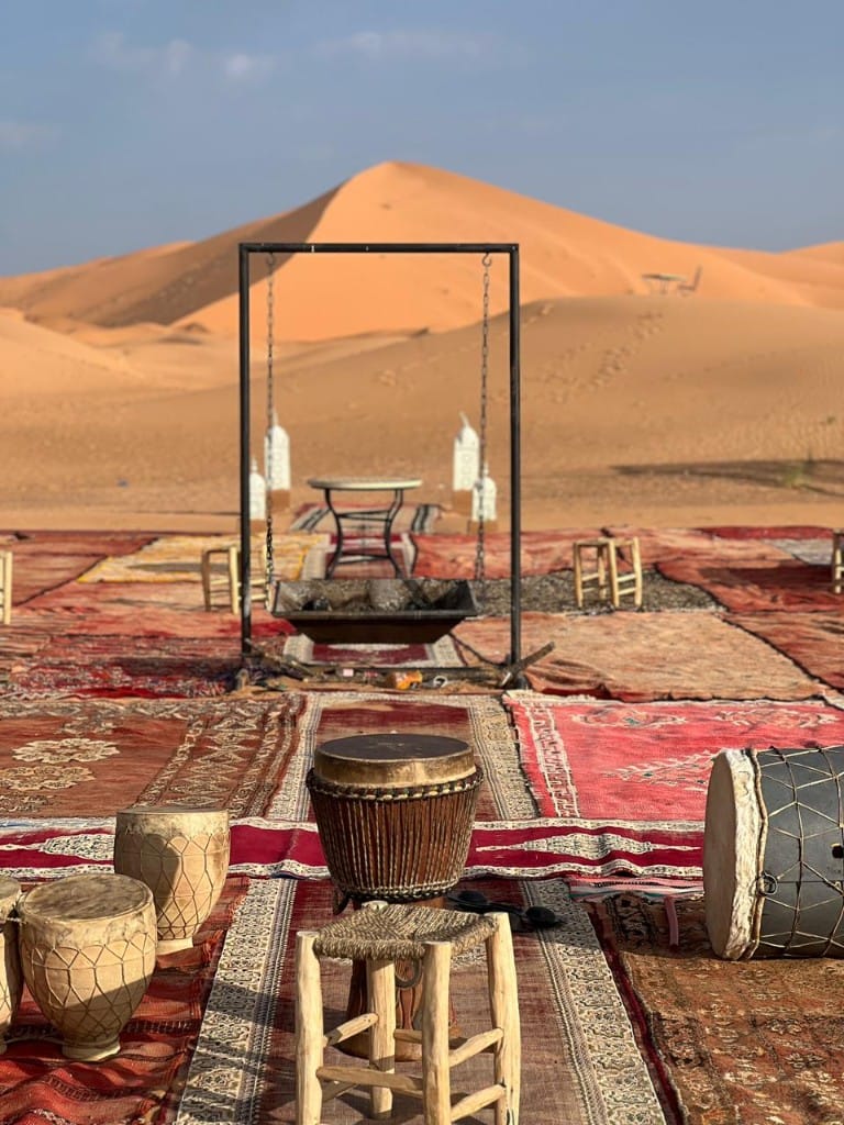 Sahara camp setup with traditional drums and carpets
